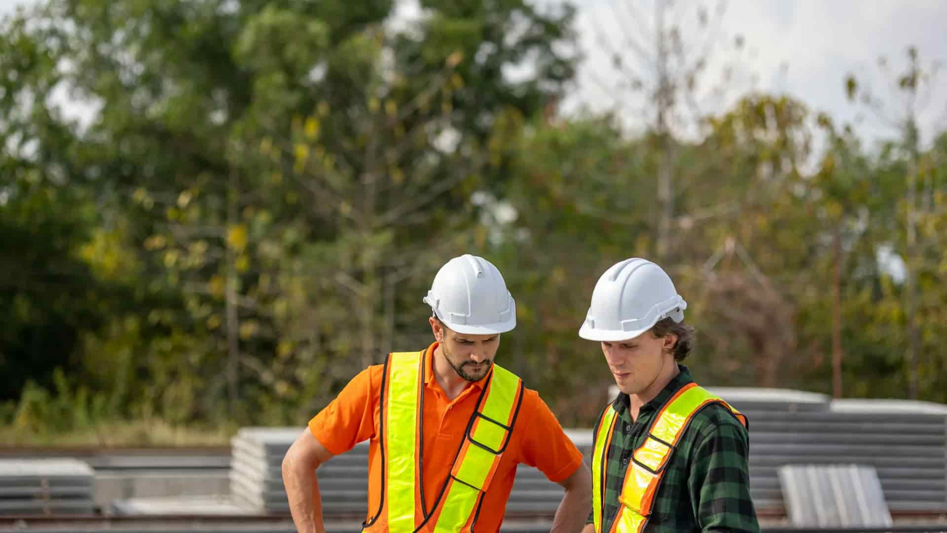 Two construction professionals reviewing project information together at an active worksite.